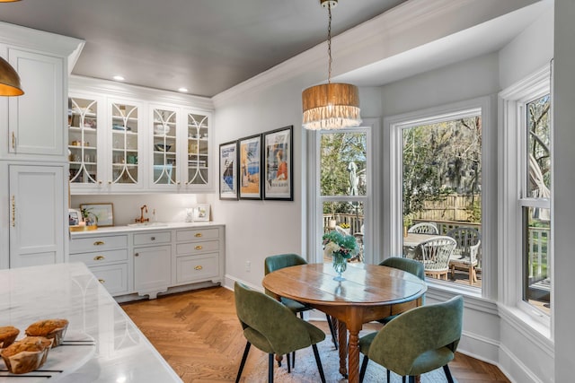 dining room with baseboards, a chandelier, plenty of natural light, and ornamental molding