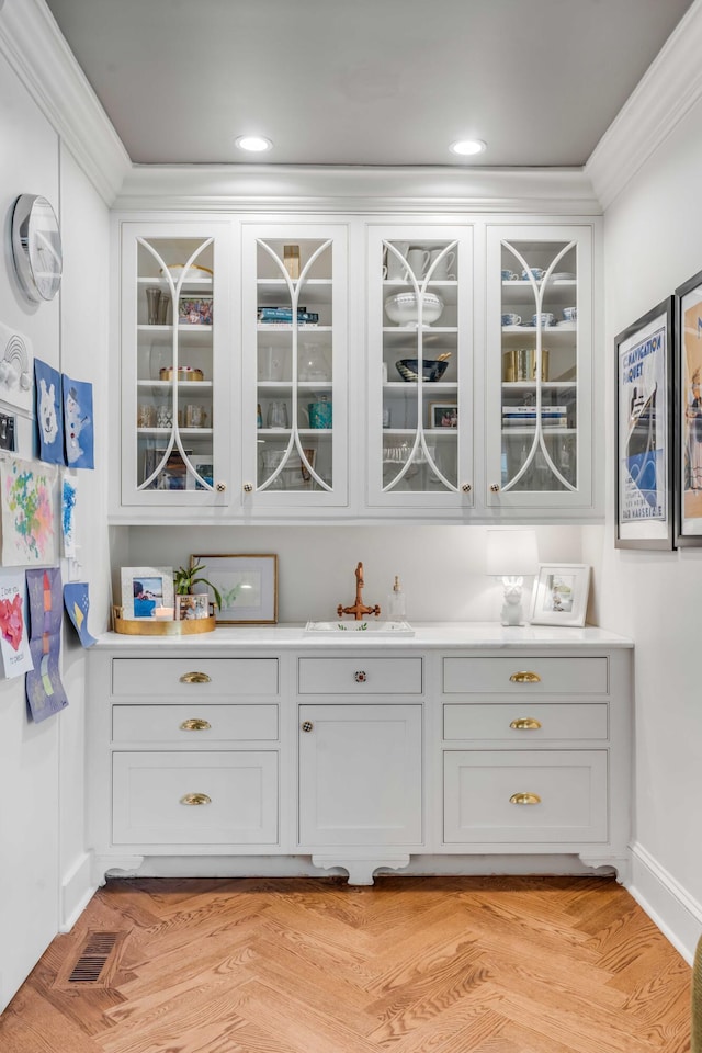bar with visible vents, a sink, and crown molding