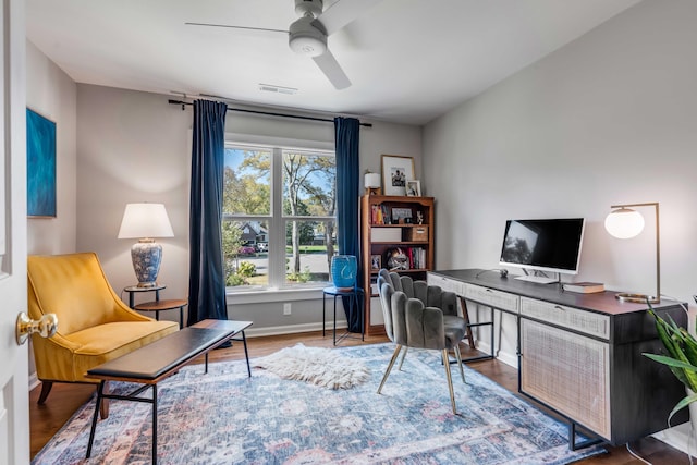 office featuring visible vents, a ceiling fan, baseboards, and wood finished floors