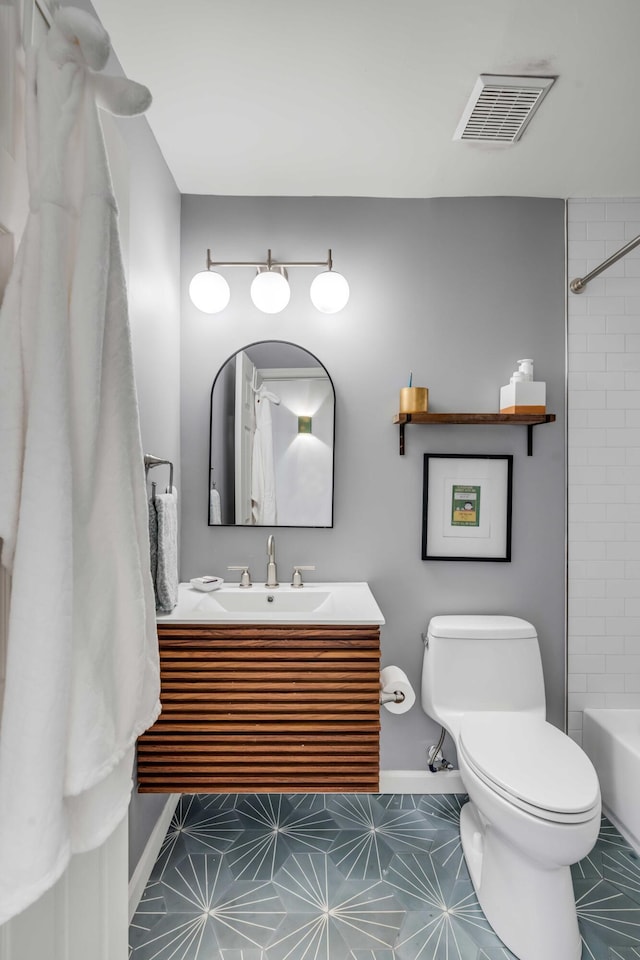 bathroom featuring vanity, toilet, tile patterned floors, baseboards, and visible vents