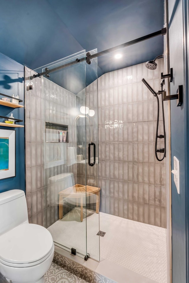 full bathroom featuring toilet, a shower stall, and tile patterned flooring