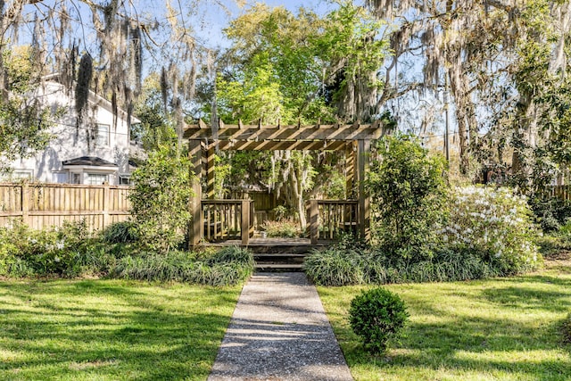 view of home's community featuring fence, a wooden deck, and a lawn
