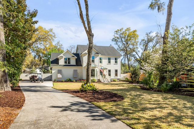 colonial house with fence, driveway, and a front yard