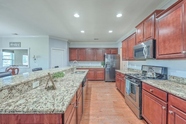 kitchen with light wood-style flooring, appliances with stainless steel finishes, light stone counters, crown molding, and a sink