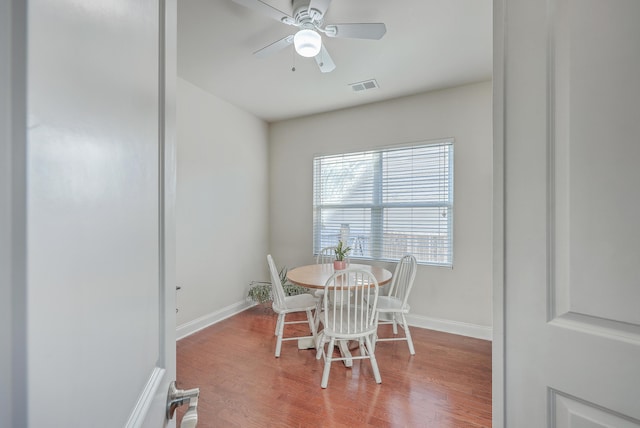 dining area featuring a ceiling fan, visible vents, baseboards, and wood finished floors