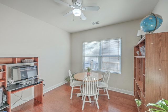 dining space with ceiling fan, wood finished floors, visible vents, and baseboards