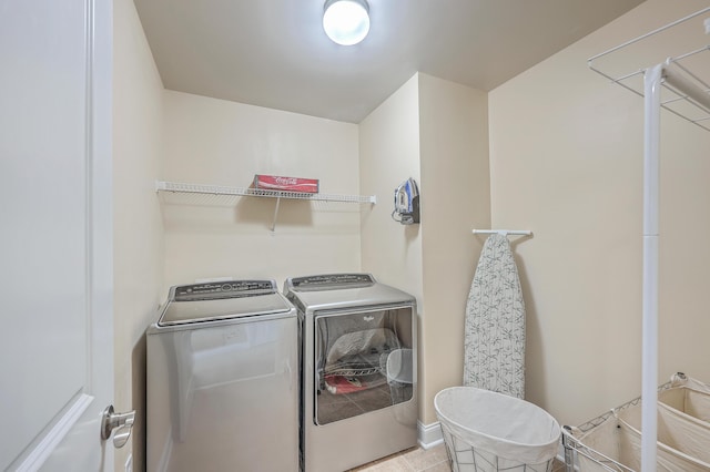 clothes washing area with laundry area, independent washer and dryer, and tile patterned flooring