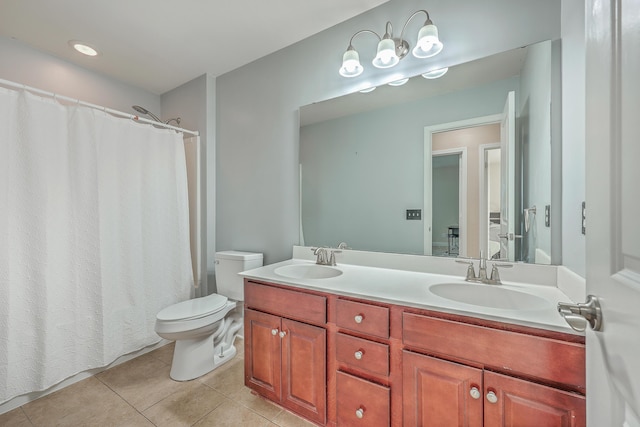 full bath featuring toilet, double vanity, a sink, and tile patterned floors