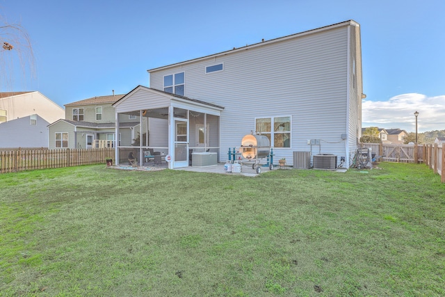 back of property featuring a lawn, a patio area, a fenced backyard, and a sunroom