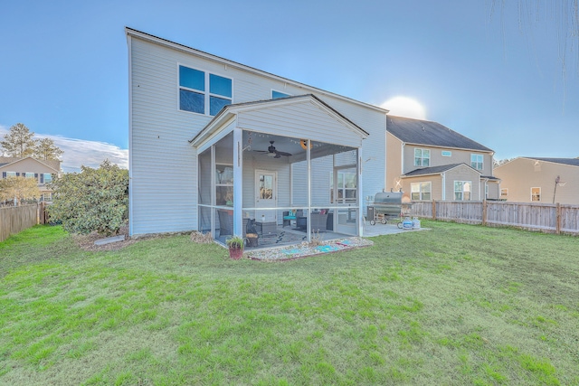 rear view of property featuring a patio, a lawn, a fenced backyard, and a sunroom