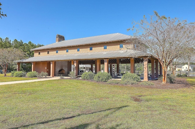 view of front of property featuring metal roof, a front lawn, and a chimney