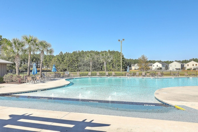 community pool with fence and a patio