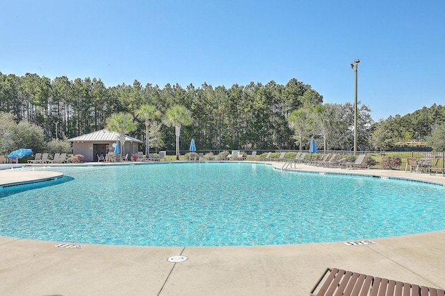 pool with a patio area and fence