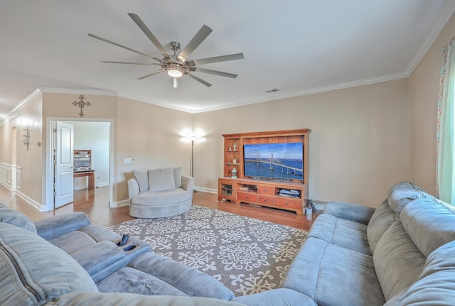 living room with ornamental molding, visible vents, ceiling fan, and wood finished floors