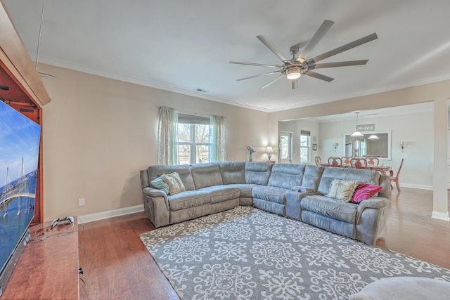 living room with visible vents, baseboards, a ceiling fan, hardwood / wood-style floors, and crown molding