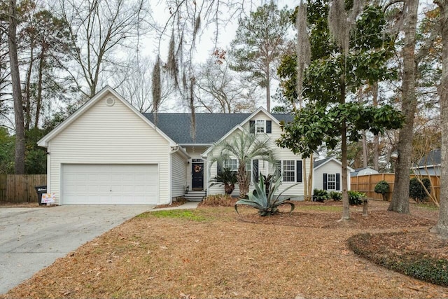 view of front of house with concrete driveway, fence, and a garage