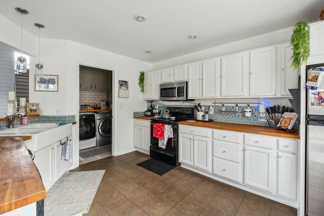 kitchen featuring separate washer and dryer, a sink, butcher block countertops, stainless steel microwave, and black electric range oven