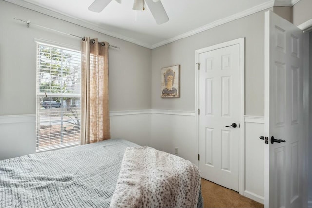 carpeted bedroom featuring a ceiling fan and ornamental molding