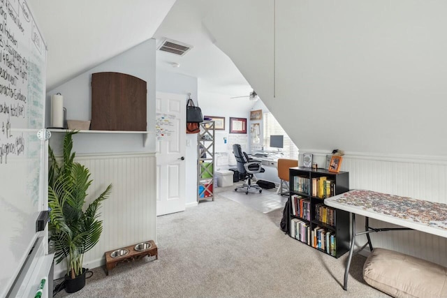 home office featuring a wainscoted wall, lofted ceiling, and carpet flooring