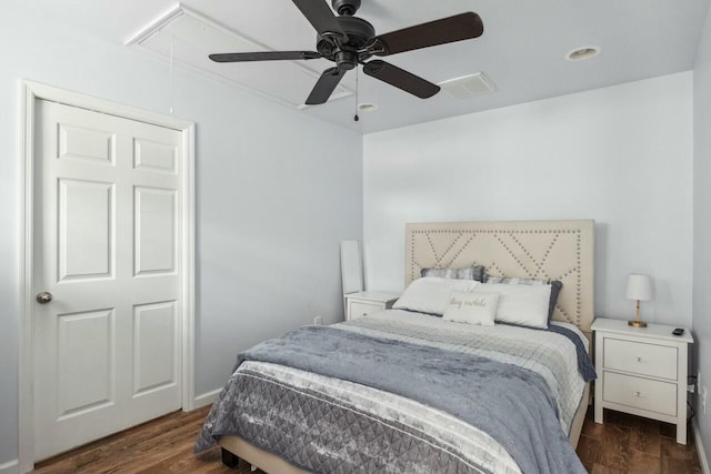 bedroom featuring dark wood-type flooring, attic access, and a ceiling fan