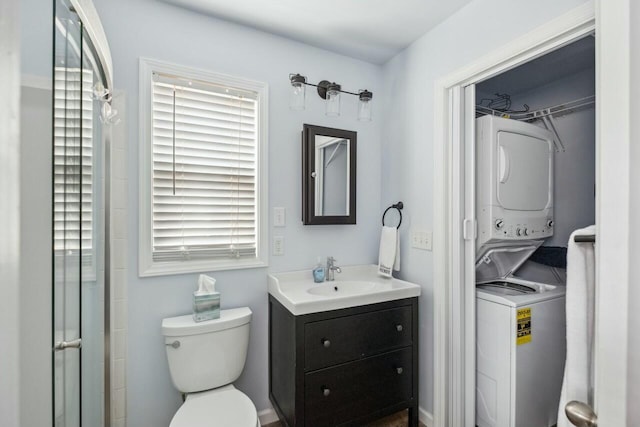 full bathroom featuring a walk in closet, stacked washer and dryer, vanity, and toilet