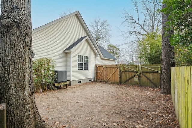 exterior space with a gate, central AC unit, fence, roof with shingles, and crawl space