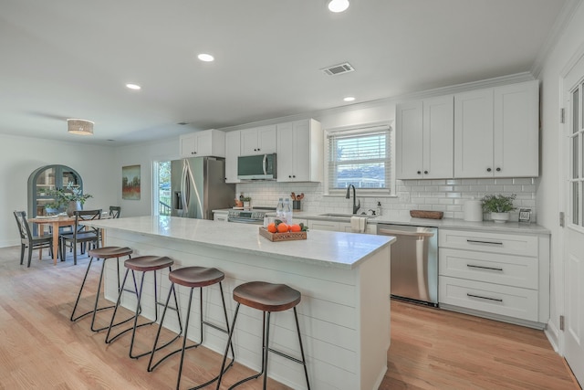 kitchen with a kitchen island, white cabinets, and appliances with stainless steel finishes