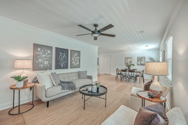 living room with light hardwood / wood-style floors, ceiling fan, and crown molding