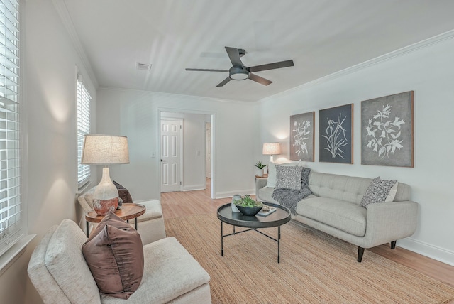 living room featuring light wood-type flooring, ceiling fan, and crown molding