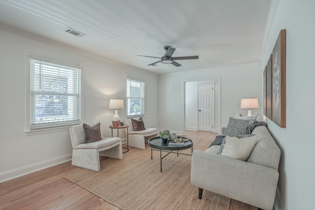 living room with ceiling fan, light wood-type flooring, and ornamental molding