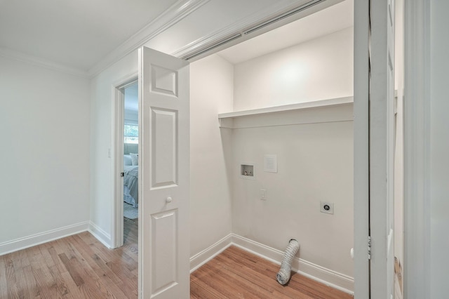 laundry room featuring hookup for an electric dryer, ornamental molding, hookup for a washing machine, and light hardwood / wood-style flooring