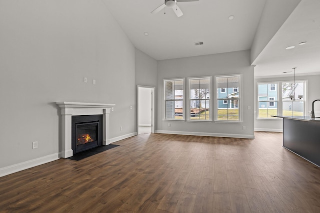 772 Opal Wing St, Moncks Corner, SC 29461 - unfurnished living room with ceiling fan, dark wood finished floors, a fireplace with flush hearth, baseboards, and high vaulted ceiling