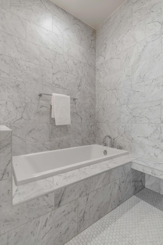 bathroom with tile walls and a relaxing tiled tub