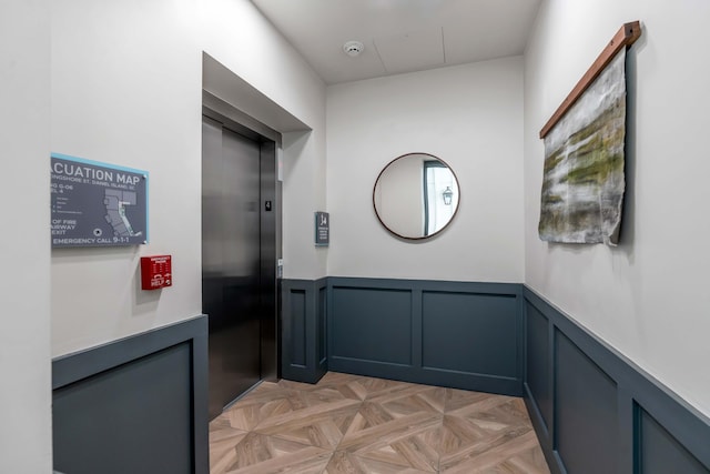 corridor featuring elevator and light parquet floors