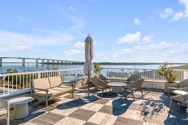 wooden deck featuring a water view and an outdoor hangout area