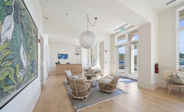 living area featuring light hardwood / wood-style floors and a high ceiling