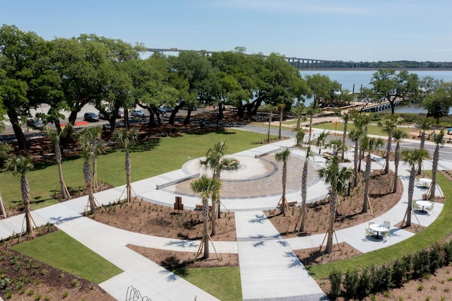 view of home's community with a water view and a lawn