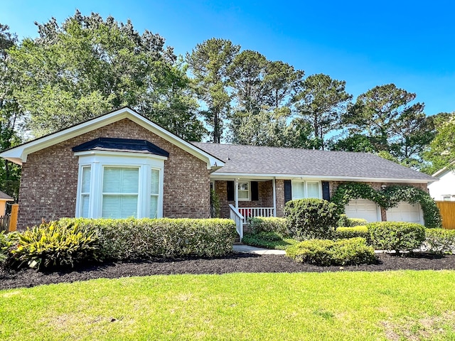 946 Law Ln, Mount Pleasant, SC 29464 - view of front of home with an attached garage, brick siding, a front lawn, and a porch