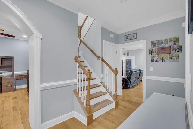 stairway featuring crown molding, hardwood / wood-style floors, and ceiling fan