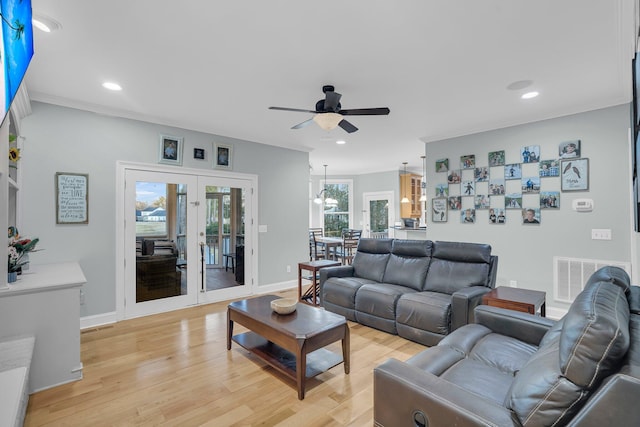 living room with ceiling fan, ornamental molding, light hardwood / wood-style floors, and french doors