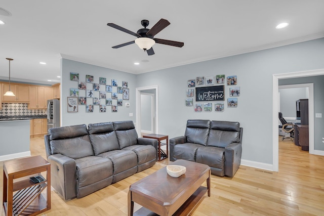 living room featuring crown molding, ceiling fan, and light wood-type flooring