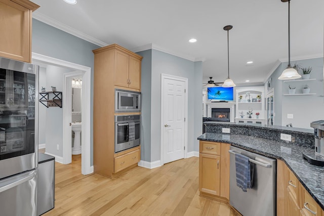 kitchen with appliances with stainless steel finishes, light brown cabinetry, hanging light fixtures, crown molding, and light hardwood / wood-style flooring