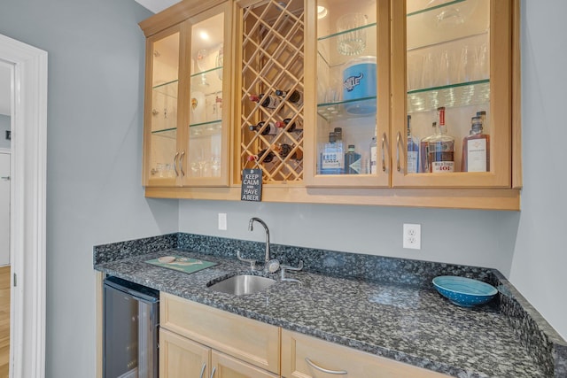 bar with sink and dark stone countertops