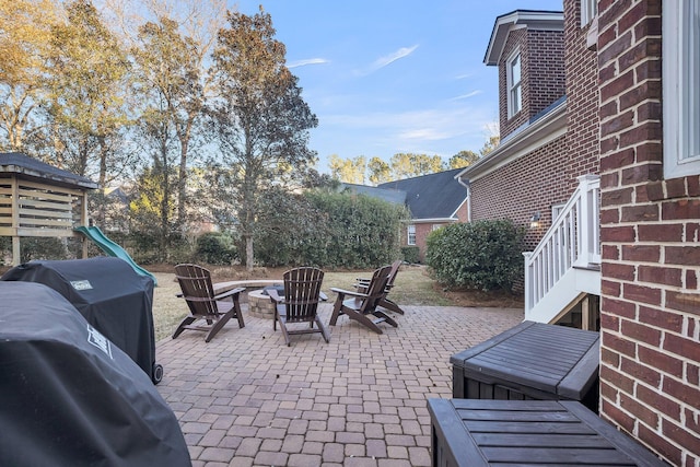 view of patio / terrace with area for grilling, a playground, and a fire pit