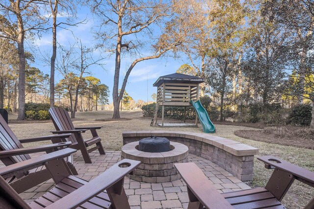 view of patio with an outdoor fire pit and a playground