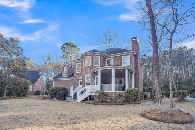 view of front of home featuring a front lawn and a sunroom