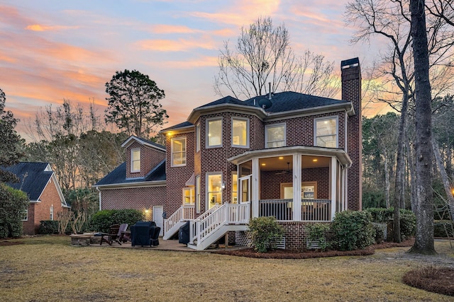 view of front of house with a fire pit and a lawn