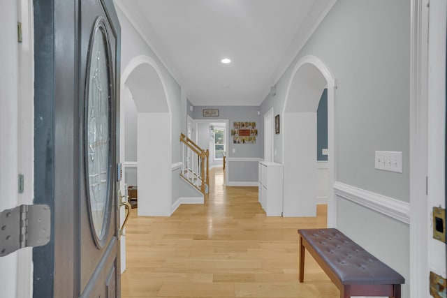 foyer entrance with crown molding and light hardwood / wood-style floors