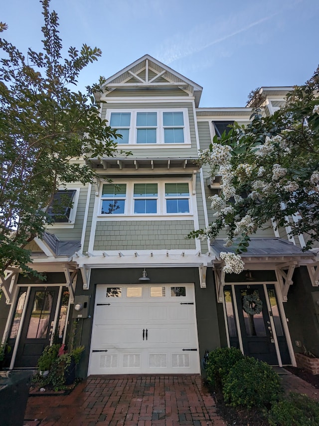 multi unit property with a garage and decorative driveway