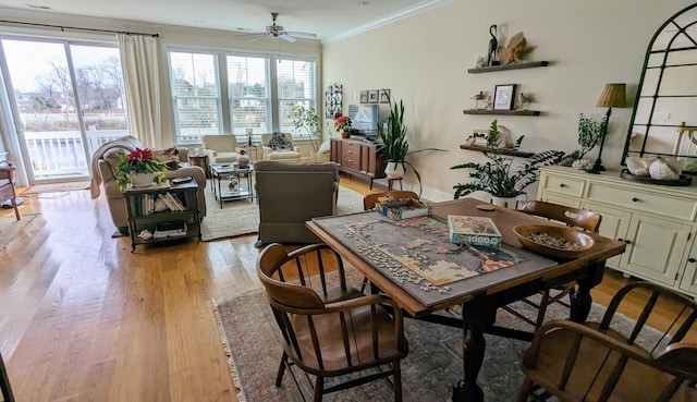 dining area featuring baseboards, crown molding, light wood finished floors, and ceiling fan